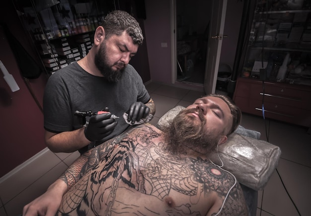 Mistrz sztuki tatuowania podczas sesji tatuażysty