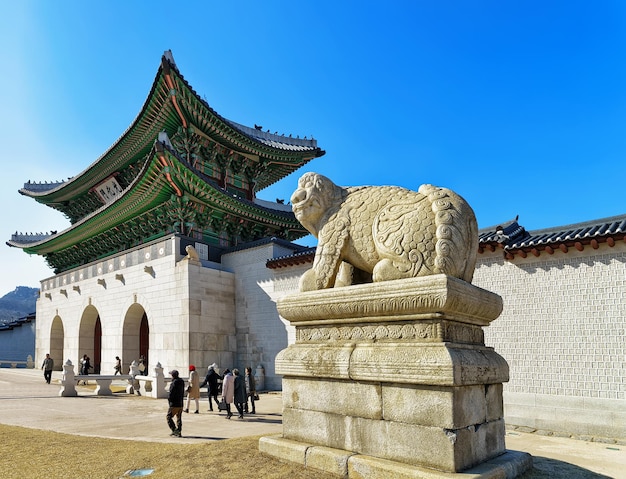 Mitologiczny Lew Posąg Haechi Przy Wejściu Do Pałacu Gyeongbokgung W Seulu, W Korei Południowej. Ludzie Na Ulicy
