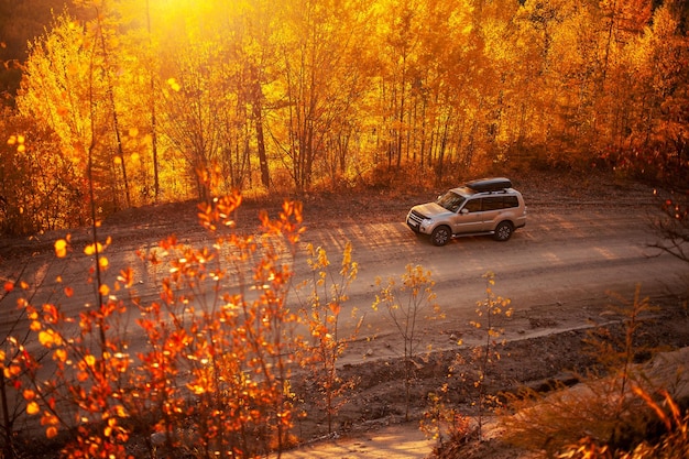 Zdjęcie mitsubishi pajero na malowniczej jesiennej drodze w górach