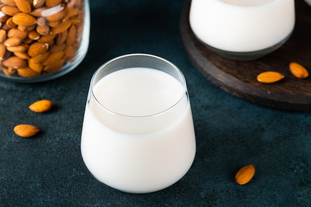 Mleko migdałowe z migdałami na ciemnym tle Mleko wegańskie Ekologiczne mleko