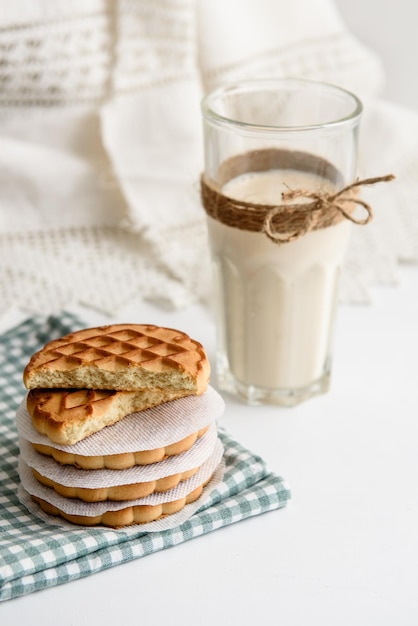 Mleko w szklance i ciasteczka na stole