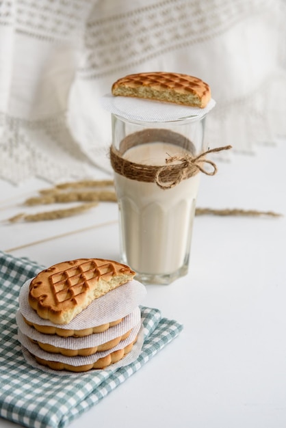 Mleko w szklance i ciasteczka na stole