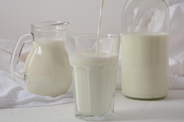 Mleko w szklance, słoiku i butelce na białym tle