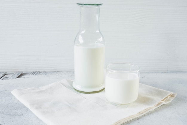 Mleko W Szklanej I Mlecznej Butelce Na Białym Drewnianym Tle