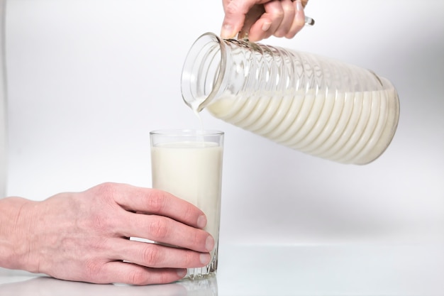 Zdjęcie mleko wlewa się do szklanki.
