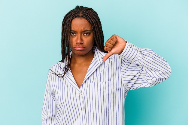 Młoda african american kobieta na białym tle na niebieskim tle pokazując kciuk w dół i wyrażając niechęć.