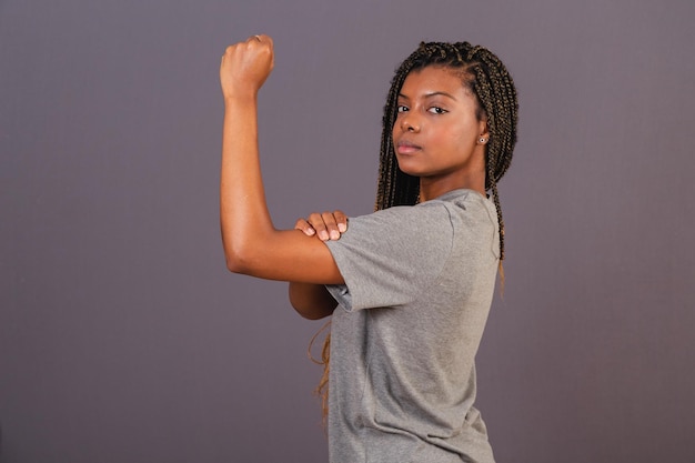Młoda afro brazylijska kobieta pokazująca zaciśniętą pięść znak bojowego feminizmu wzmacniającego pozycję kobiet