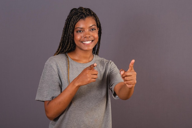 Młoda afro brazylijska kobieta wskazująca coś daleko palcami wskazującymi kierunek