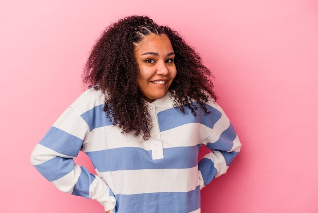 Młoda Afroamerykanin kobieta na białym tle na różowej ścianie szczęśliwa, uśmiechnięta i wesoła