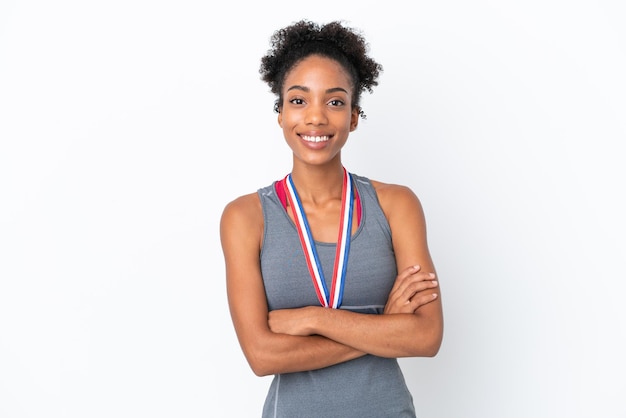 Młoda Afroamerykanka z medalami na białym tle trzymająca ręce skrzyżowane w pozycji czołowej