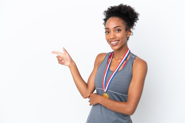 Młoda Afroamerykanka z medalami na białym tle wskazującym palcem w bok