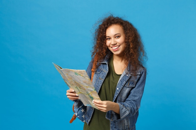 Młoda Afroamerykańska Dziewczyna Nastoletnia Studentka W Dżinsowych Ubraniach, Mapa Trzymania Plecaka Odizolowana Na Niebieskiej ścianie