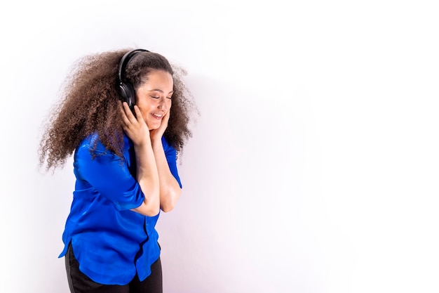 Młoda afrohaired dziewczyna słucha muzyki przez słuchawki na na białym tle