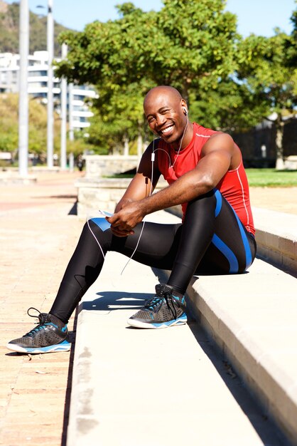 Młoda afrykańska męska atleta odpoczywa outdoors