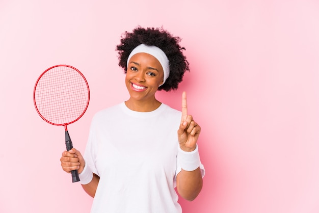 Młoda Amerykanin Afrykańskiego Pochodzenia Kobieta Bawić Się Badminton Odizolowywał Pokazywać Liczbę Jeden Z Palcem.