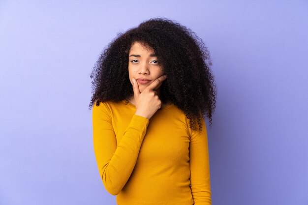 Młoda amerykanin afrykańskiego pochodzenia kobieta na purpurach izoluje mieć wątpliwości