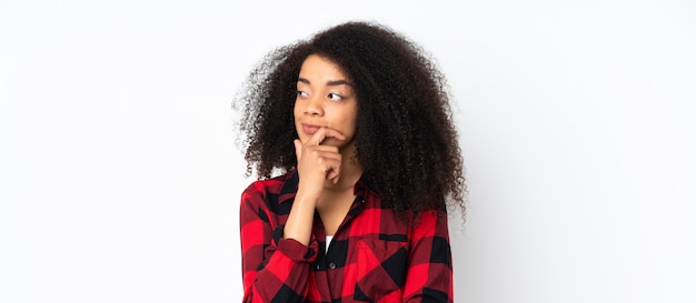 Młoda amerykanin afrykańskiego pochodzenia kobieta nad odosobnioną ścianą ma wątpliwości z zmieszanym twarzy wyrażeniem