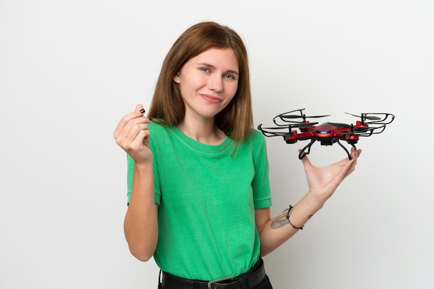 Młoda Angielka trzymająca drona na białym tle robienie pieniędzy gest