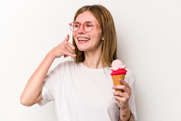 Młoda Angielka trzymająca lody na białym tle pokazująca gest palcami rozmowy przez telefon komórkowy