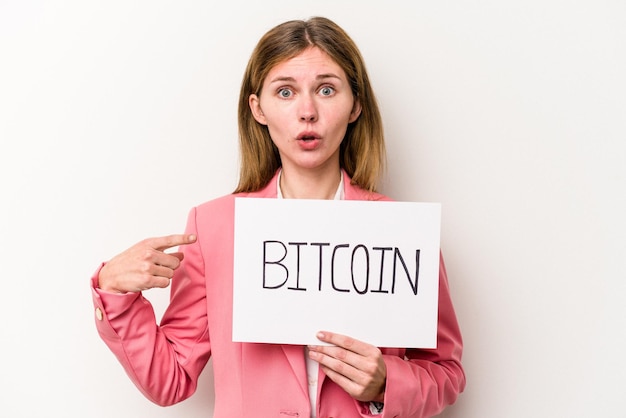 Młoda angielska kobieta biznesu trzymająca tabliczkę z bitcoinami na białym tle skierowaną w bok