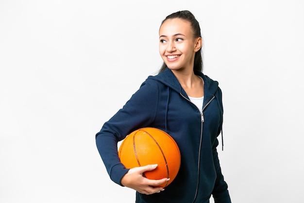 Młoda Arabska kobieta na białym tle gra w koszykówkę