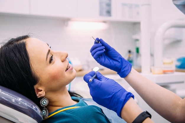 Zdjęcie młoda atrakcyjna brunetka na konsultacji dentystycznej higieny jamy ustnej i leczenia