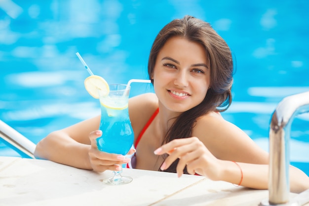 Młoda atrakcyjna kobieta relaks przy basenie