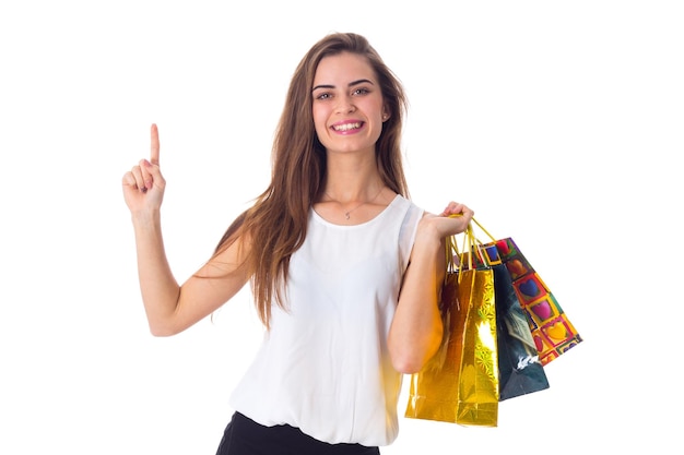 Młoda atrakcyjna kobieta w białej bluzce i czarnej spódnicy trzymająca torby na zakupy