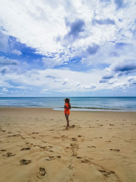 Młoda atrakcyjna kobieta w kapeluszu i szkłach na brzeg błękitny morze cieszy się, Tajlandia