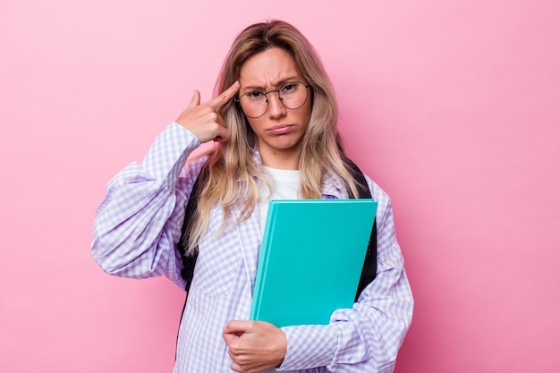 Młoda australijska kobieta studentka na białym tle na różowym tle pokazując gest rozczarowania palcem wskazującym.