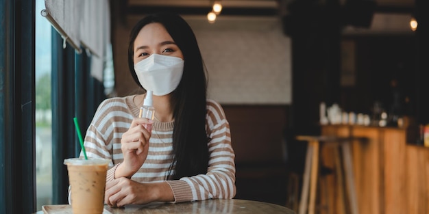 Młoda Azjatka nosząca chirurgiczną maskę na twarz, aby rozpocząć nowy, normalny styl życia w miejskim mieście