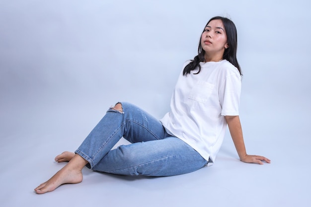 Młoda Azjatka siedząca i nosząca pustą białą koszulkę