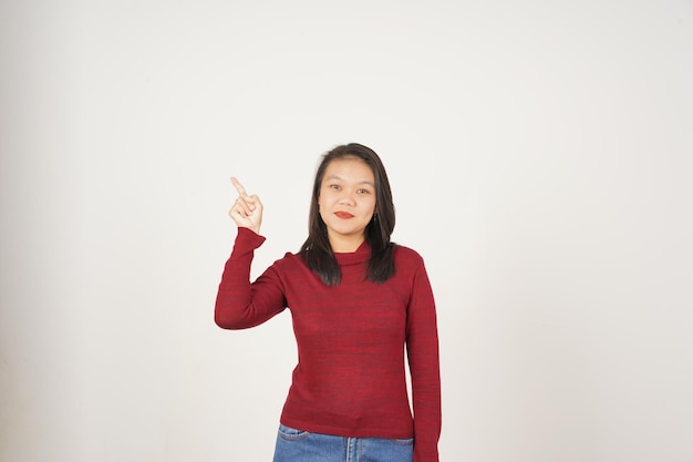 Młoda Azjatka w czerwonej koszuli wskazującej na boczną przestrzeń kopiowania izolowaną na białym tle