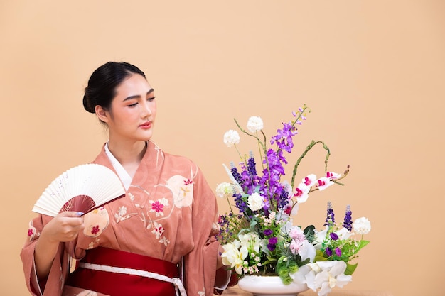 Młoda Azjatka z Japonii w wieku 20 lat nosi tradycyjne kimono robi kompozycję kwiatową z Ikebany