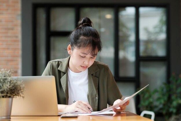 Młoda azjatycka biznesmenka lub studentka pracująca online na laptopie