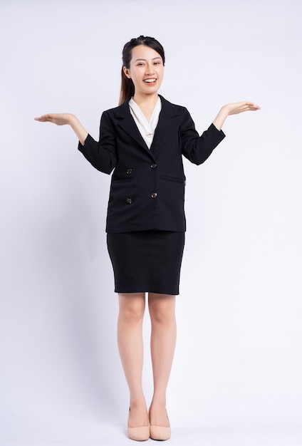 Młoda azjatycka bizneswoman stojąca na białym tle