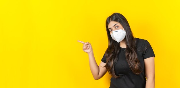 Młoda Azjatycka Dziewczyna Nosząca Medyczną Maskę Na Twarz W Swobodnym Ubraniu Na żółtym Tle