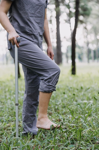 Młoda azjatycka fizjoterapeuta pracująca ze starszą kobietą podczas chodzenia z chodzikiem