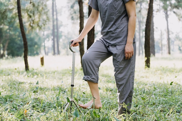 Młoda azjatycka fizjoterapeuta pracująca ze starszą kobietą podczas chodzenia z chodzikiem