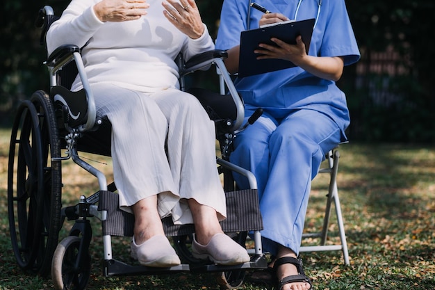 Młoda azjatycka fizjoterapeuta pracująca ze starszą kobietą podczas chodzenia z chodzikiem