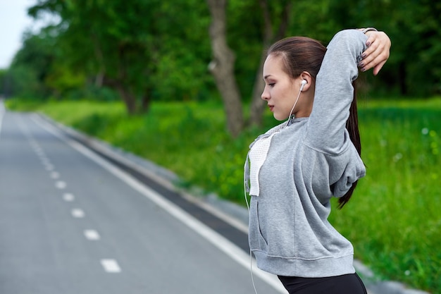 Młoda azjatycka kobieta fitness rozciągająca ręce po biegu na świeżym powietrzu po biegu