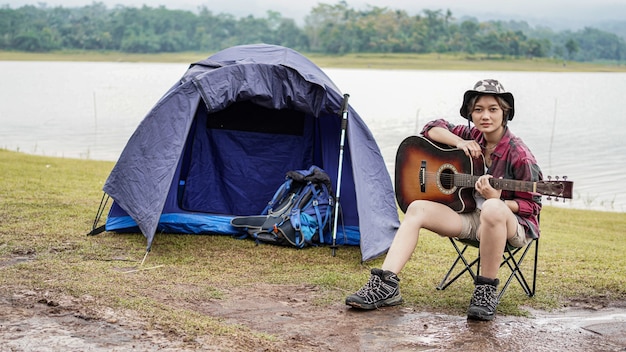 Młoda Azjatycka Kobieta Gra Na Gitarze Na Kempingu