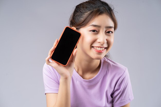 Młoda Azjatycka kobieta pokazuje pusty ekran smartfona
