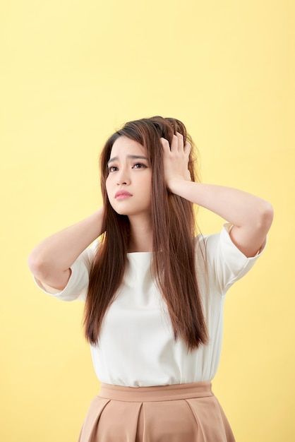 Młoda azjatycka kobieta szczotkująca włosy i rozczarowująca kondycję włosów