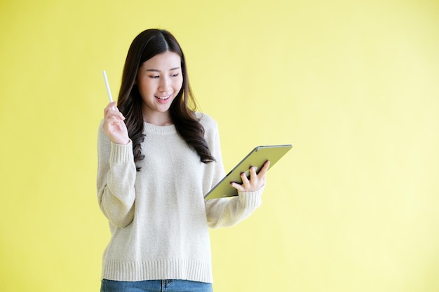 Zdjęcie młoda azjatycka kobieta trzyma cyfrową tabletkę uśmiechając się
