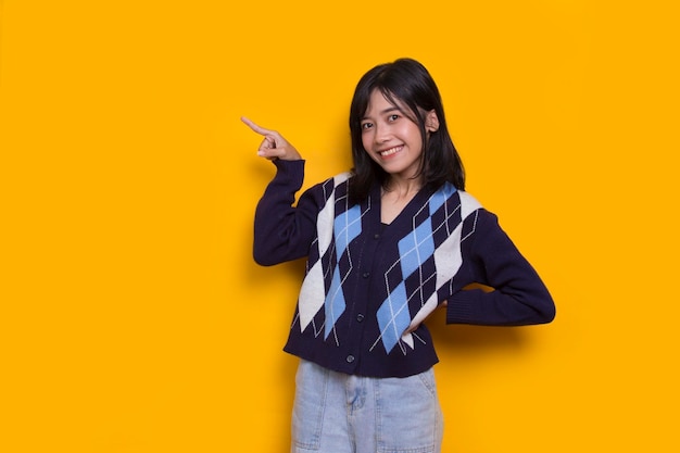 młoda azjatycka kobieta wskazująca palcami w różnych kierunkach na żółtym tle