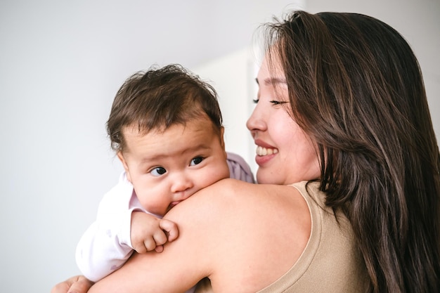 Zdjęcie młoda azjatycka matka trzymająca małą dziewczynkę i uśmiechająca się
