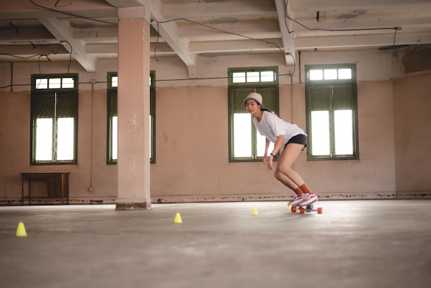 Młoda Azjatycka nastolatka gra na deskorolce miejski sport szczęśliwy i zabawny styl życia z deskorolką