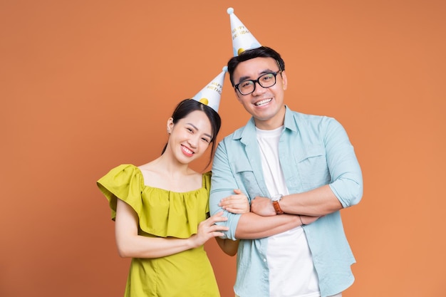 Młoda azjatycka para trzymająca tort urodzinowy na tle
