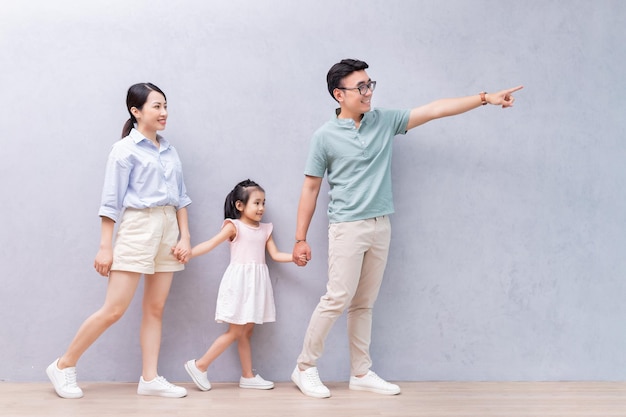 Młoda azjatycka rodzina stojąca na tle
